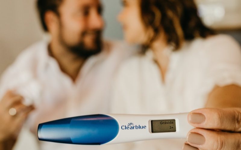 man in white dress shirt holding blue and white digital thermometer