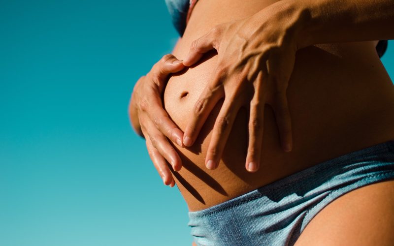 closeup photography of pregnant woman wearing blue panty